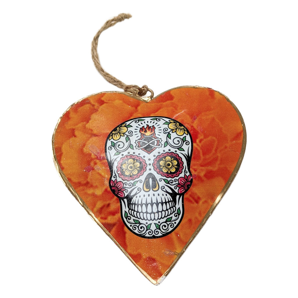 Heart-shaped ornament with a colorful skull design on an orange floral background